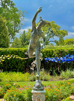 Spring Glass Sculpture Behind Garden Statue of Winged Mercury